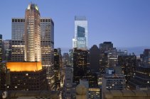 Edificios iluminados al atardecer en el centro de Manhattan mirando hacia el norte, Nueva York, Estado de Nueva York, Estados Unidos - foto de stock