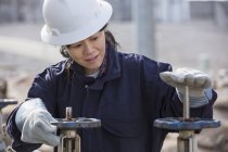 Ingeniera de potencia femenina ajustando válvulas de agua en planta de energía - foto de stock