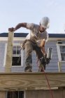 Carpinteiro hispânico usando pistola de prego na construção home deck — Fotografia de Stock