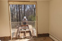 Spanisch Tischler entfernt neu geschnittene Tür Zugang zu Deck zu Hause — Stockfoto