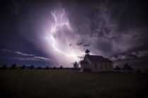 Tempestade elétrica bonita e brilhante com uma igreja em primeiro plano; Mandíbula de Alce, Saskatchewan, Canadá — Fotografia de Stock