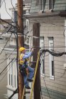 Câble lineman installant un filtre sur les poteaux électriques de la ville — Photo de stock
