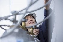 Ingeniera de potencia femenina verificando inyectores con gas comprimido en central eléctrica - foto de stock