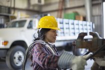 Engenheira de energia feminina com cabo de alimentação na garagem de serviço — Fotografia de Stock