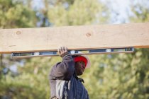 Carpenter measuring horizontal roof joist — Stock Photo