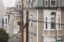 Cable lineman subindo uma escada no poste de energia da cidade — Fotografia de Stock