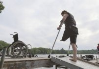 Donna con una gamba sola in attesa sul molo per andare a sciare — Foto stock