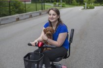 Giovane donna con paralisi cerebrale cavalcare lo scooter con il suo cane — Foto stock