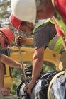 Construction workers using torque wrench to secure water main section with bolts — Stock Photo