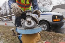 Geschnittenes Bild eines Technikers der Wasserbehörde, der den Hydranten abschaltet, um Wasserleitungen zu spülen — Stockfoto