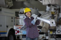 Ingeniera de potencia femenina moviendo una lámpara de calle en garaje de servicio - foto de stock