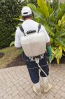 Pest control technician with portable spray rig using spray hose — Stock Photo
