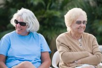 Zwei Seniorinnen sitzen zusammen und lächeln — Stockfoto
