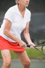 Mujer mayor jugando al tenis - foto de stock