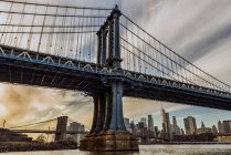 Манхэттенский мост на закате, Бруклинский мост-парк; Бруклин, Нью-Йорк, Соединенные Штаты Америки — стоковое фото