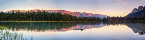 Tranquil lake with reflections in Elk Lakes Provincial Park at sunset; British Columbia, Canada — стоковое фото