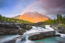 Double rainbow shining over a rugged waterfall and the Rocky Mountains, Jasper National Park; Alberta, Canada — Stockfoto