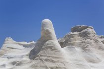 Sand formations against a blue sky, Sarakiniko Beach; Milos Island, Cyclades, Greece — стоковое фото