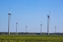 Wind turbines on farmland with a farm field in the foreground; Saint Remi, Quebec, Canada — Foto stock