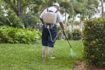 Pest control technician with portable spray rig using  spray nozzle and hose — Stock Photo