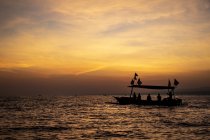 Indonesian jukung, traditional wooden outrigger canoe at sunrise; Lalang, Bali, Indonesia — Stock Photo