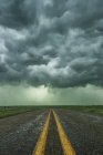 Empty highway disappearing into the mouth of a storm somewhere in the Texas Panhandle; Texas, United States of America — Stock Photo