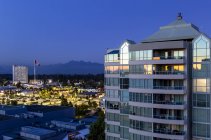 Residential building at twilight with a Canada Flag and mountains in the distance; Surrey, British Columbia, Canada — Stock Photo