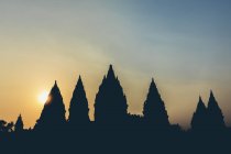 Coucher de soleil au temple Prambanan avec des sommets silhouettés ; Yogyakarta, Indonésie — Photo de stock
