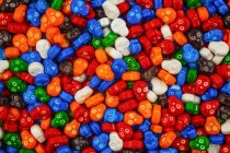 Барвиста купа цукерок черепа в червоному, синьому, помаранчевому, зеленому, білому, помаранчевому і коричневому — стокове фото