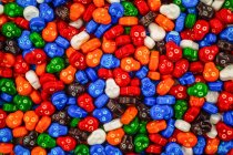 Pilha colorida de doces de crânio em vermelho, azul, laranja, verde, branco, laranja e marrom — Fotografia de Stock