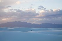 Люди играют на дюнах у Национального памятника Уайт-Сэндс; Аламогордо, Нью-Мексико, Соединенные Штаты Америки — стоковое фото