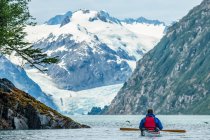 Kayaker remando em Prince William Sound, Alaska com belas montanhas à distância; Alaska, Estados Unidos da América — Fotografia de Stock