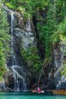 Kajakfahrer vor dem Wasserfall, Prince William Sound; Alaska, Vereinigte Staaten von Amerika — Stockfoto