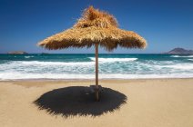 Refugio de paja en la playa con vistas al mar Egeo, Mediterráneo; Milos, Grecia - foto de stock