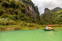 Navegar en un lago para ver el exuberante paisaje de Ninh Binh; Provincia de Ninh Binh, Vietnam - foto de stock