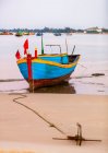 Barco de pesca colorido amarrado à praia, Ke Ga Cape; Ke Ga, Vietnã — Fotografia de Stock