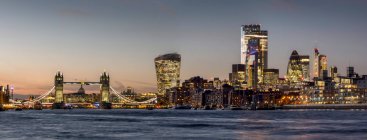 Stadtbild und Skyline von London in der Abenddämmerung mit 20 Fenchurch, 22 Bishopsgate und verschiedenen anderen Wolkenkratzern und der Themse im Vordergrund; London, England — Stockfoto