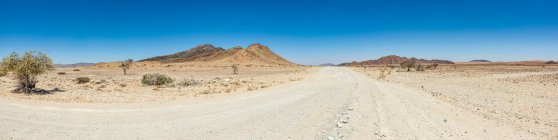 Длинная пустая дорога в пустыне, Национальный парк Намиб-Науклуфт; Намибия — стоковое фото