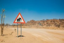 Предупреждающий знак слона на обочине дороги, по дороге к горе Брандберг, Дамараланд; регион Кунене, Намибия — стоковое фото