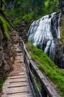 Wooden walkway leading to the Wasserlochklamm waterfall cascades in the Austrian Alps, long exposure; Landl, Austria — Stock Photo