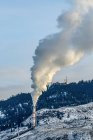 Le emissioni da una pila riempiono l'aria alla fine di un tubo; British Columbia, Canada — Foto stock