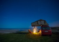 Voiture avec tente sur le toit camping près de Falcarragh Beach la nuit ; Comté de Donegal, Irlande — Photo de stock