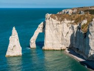 Arco natural en los acantilados de tiza con agua de color verde azulado a lo largo de la costa, complejo de tiza de Etretat; Etretat, Normandía, Francia - foto de stock