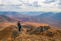 Жінка досліджує гори вздовж Демпстерського шосе восени; Юкон (Канада) — стокове фото