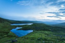 Blick im Morgengrauen über zwei Seen in den Galty Mountains; County Limerick, Irland — Stockfoto