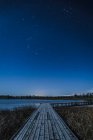 Wooden boardwalk along Lough Erne at night with stars in the sky; County Fermanagh, Ireland — Stock Photo