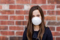 Молода дівчина стоїть у захисній масці, щоб захистити від COVID-19 під час Всесвітньої пандемії Коронавірусу; Торонто, Онтаріо, Канада. — стокове фото