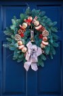 Corona decorativa de Navidad en una puerta azul de la casa; Londres, Inglaterra - foto de stock