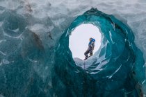 Uomo che esplora una grotta di ghiaccio; costa meridionale, Islanda — Foto stock
