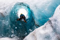 Uomo che esplora una grotta di ghiaccio; costa meridionale, Islanda — Foto stock